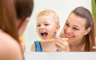 Mother teaching infant to brush